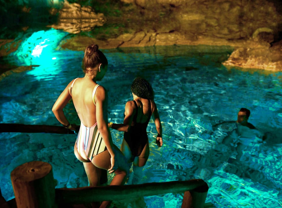 Hoyo Azul cenote at Scape Park Cap Cana — turquoise water surrounded by limestone cliff and jungle